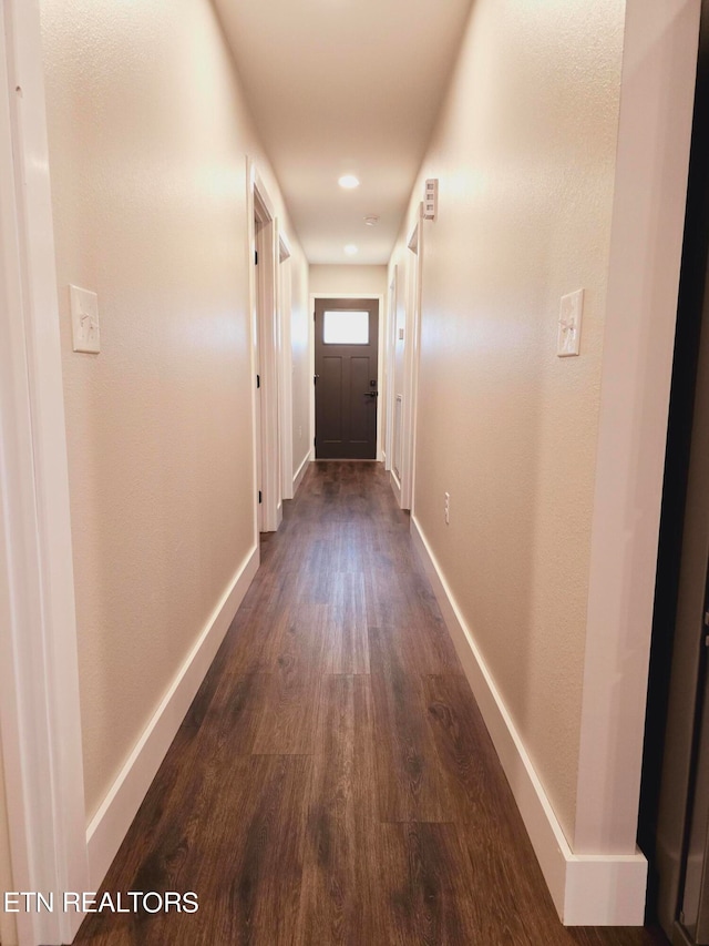 corridor with dark hardwood / wood-style flooring