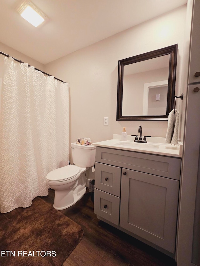 bathroom with hardwood / wood-style flooring, toilet, and vanity