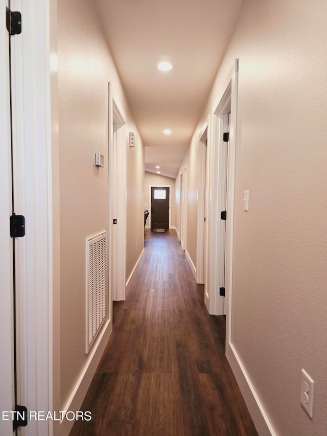 corridor with dark hardwood / wood-style flooring