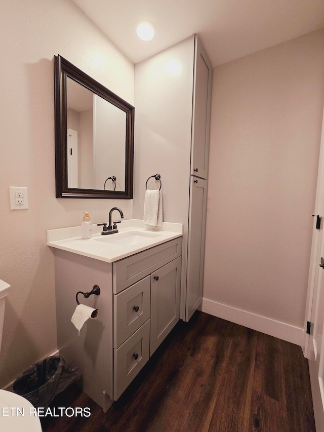 bathroom featuring vanity, toilet, and hardwood / wood-style floors