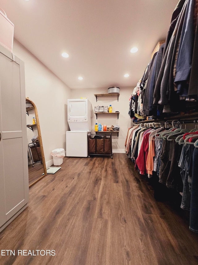 walk in closet featuring stacked washer and clothes dryer and hardwood / wood-style floors