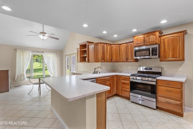 kitchen with lofted ceiling, stainless steel appliances, light tile patterned floors, ceiling fan, and kitchen peninsula