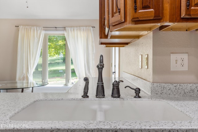 kitchen with light stone counters and sink