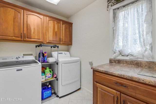 laundry area featuring cabinets, light tile patterned floors, and independent washer and dryer