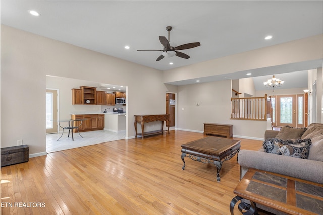 tiled living room featuring ceiling fan with notable chandelier