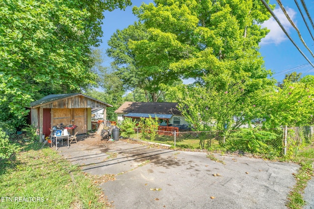 exterior space featuring an outbuilding, fence, and a storage shed