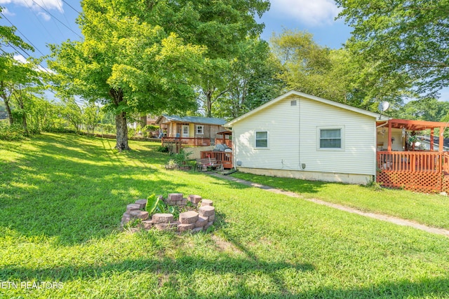 view of yard featuring a fire pit and a wooden deck