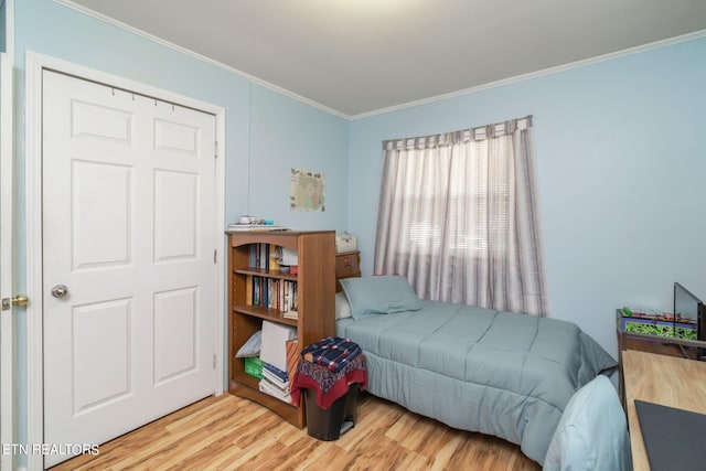 bedroom featuring crown molding and light wood-style flooring