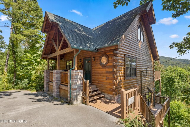 log cabin featuring covered porch