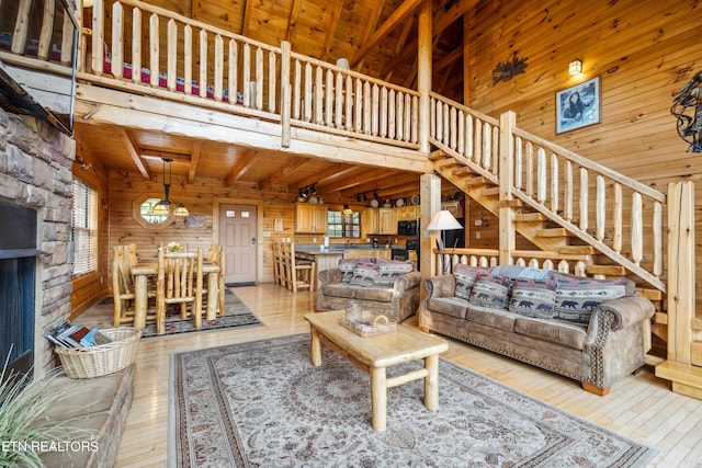 living room featuring high vaulted ceiling, wood walls, wooden ceiling, beam ceiling, and light hardwood / wood-style flooring