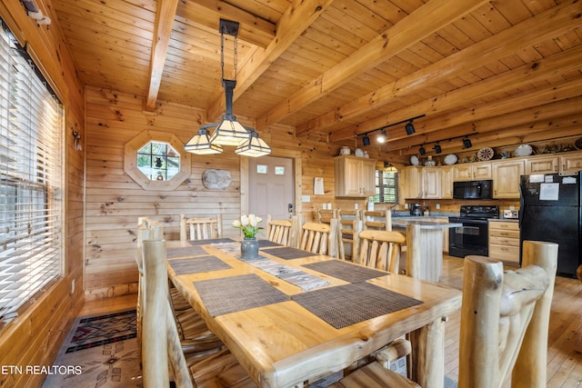 dining space with wood walls, track lighting, wooden ceiling, beam ceiling, and light hardwood / wood-style flooring