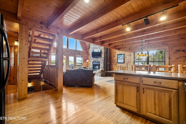 kitchen with wood walls, beamed ceiling, wood ceiling, and light wood-type flooring