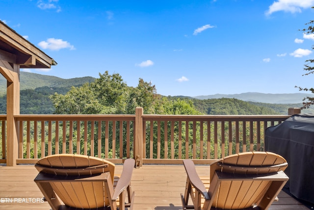 wooden terrace with area for grilling and a mountain view