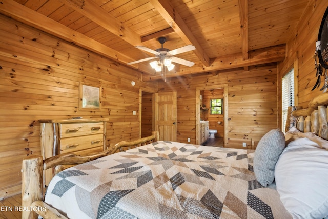 bedroom with wood ceiling, connected bathroom, wooden walls, and beamed ceiling