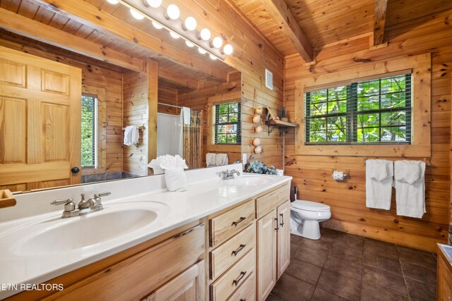 bathroom with a healthy amount of sunlight, beam ceiling, wooden walls, and wood ceiling