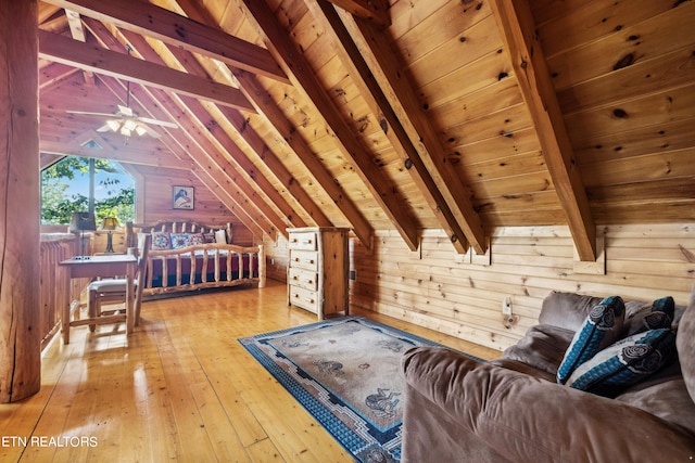 bedroom with light wood-type flooring, wooden walls, vaulted ceiling with beams, and wood ceiling