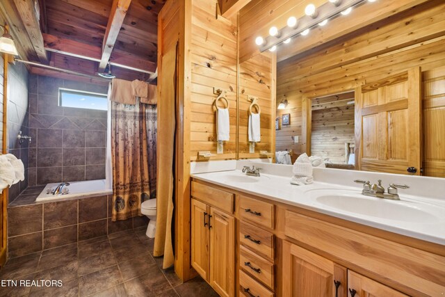 full bathroom featuring wood walls, tile patterned flooring, shower / bath combination with curtain, vanity, and toilet