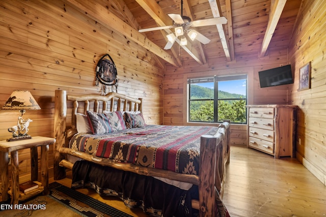 bedroom with light hardwood / wood-style floors, wooden walls, wooden ceiling, ceiling fan, and lofted ceiling with beams