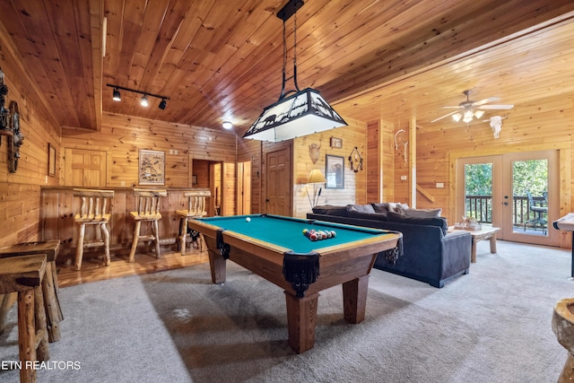 game room featuring wood ceiling, wooden walls, and rail lighting