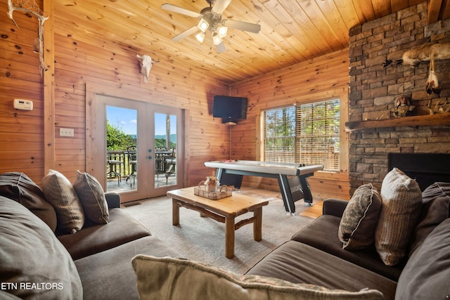 living room with french doors, a wealth of natural light, and wooden walls