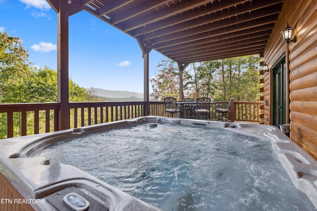 wooden deck with a mountain view and a hot tub