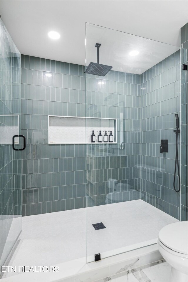 bathroom with a shower with door, tile patterned flooring, and toilet