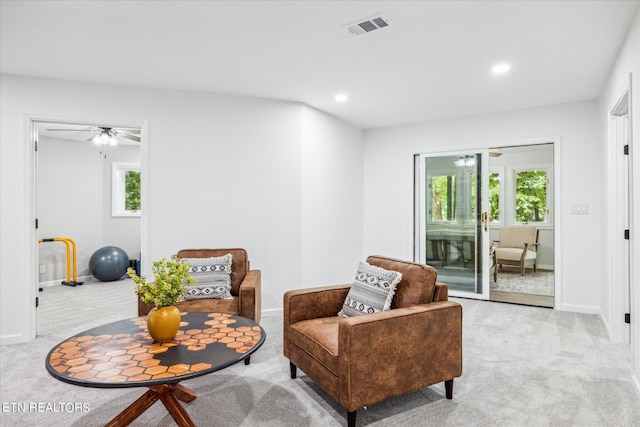 sitting room with ceiling fan and light carpet