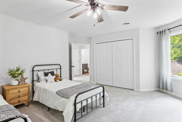 carpeted bedroom with a closet, ceiling fan, and multiple windows