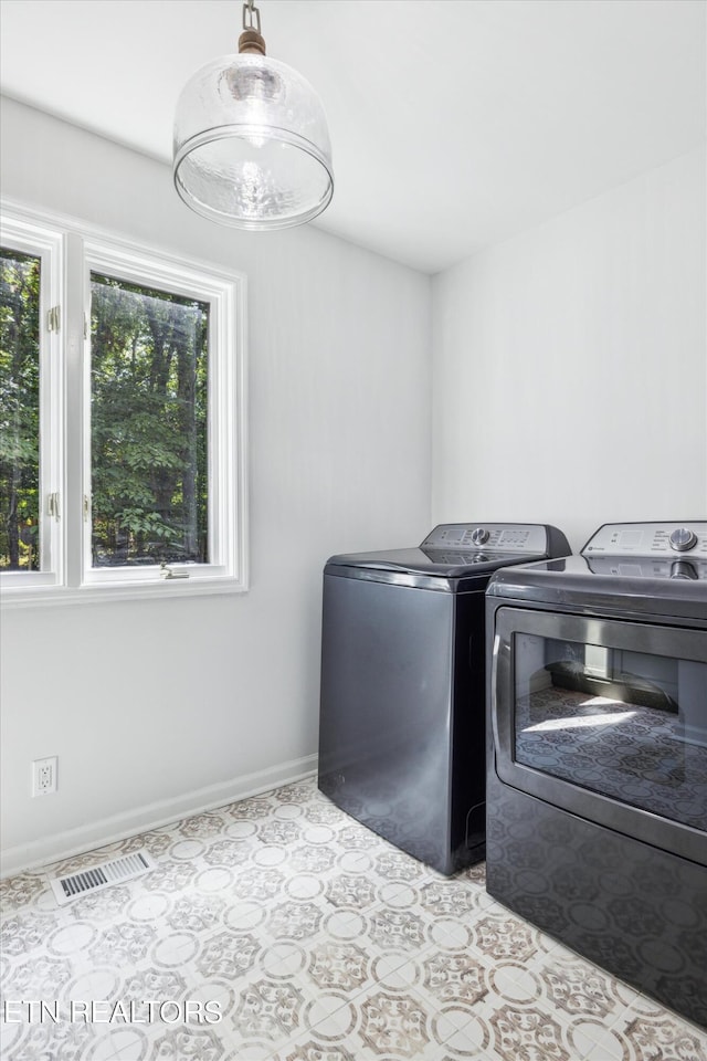 washroom featuring washing machine and dryer and light tile patterned floors