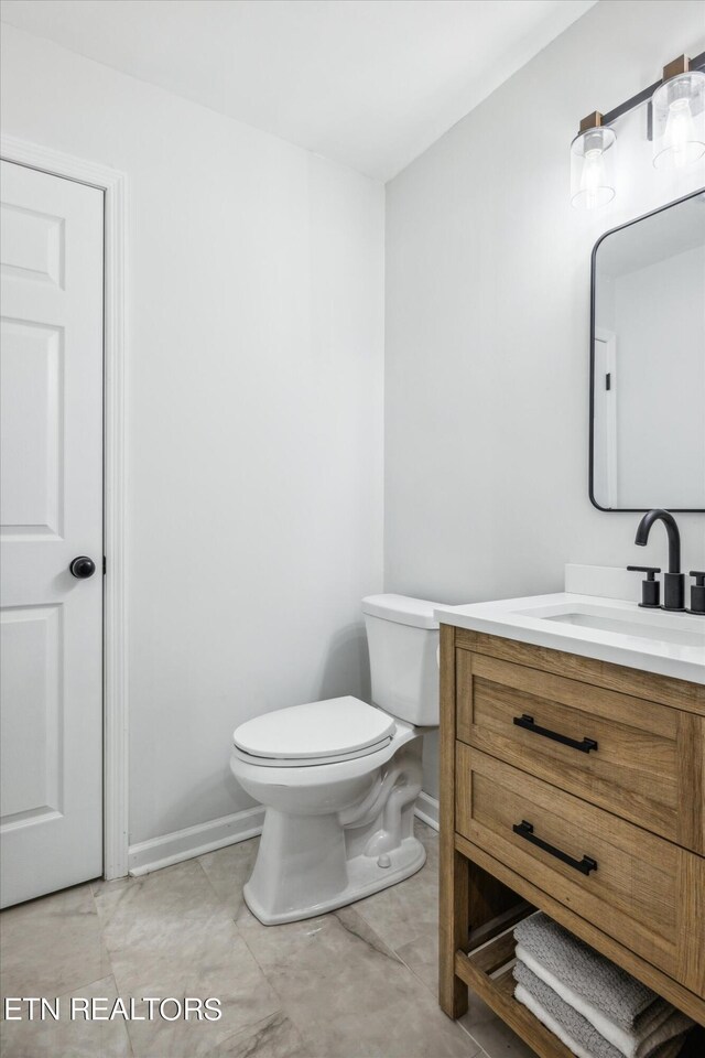 bathroom with vanity, toilet, and tile patterned flooring