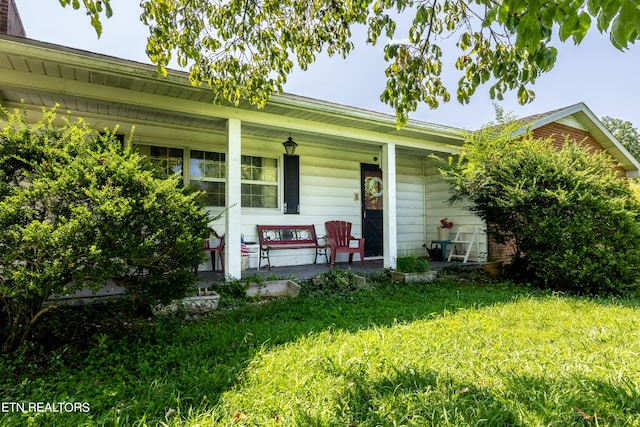 ranch-style home with a front lawn and covered porch