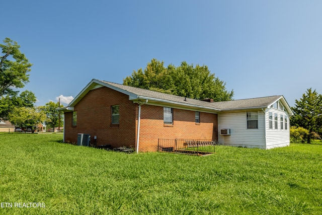 rear view of property with central AC and a lawn