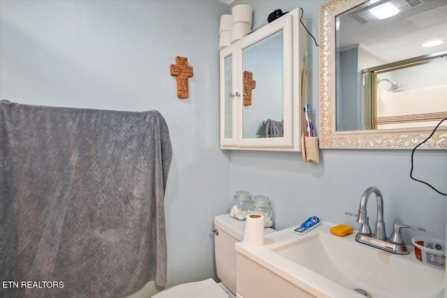 bathroom with an enclosed shower, a sink, and toilet