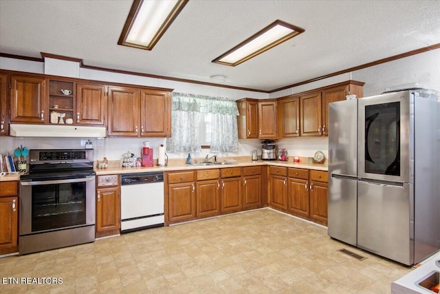 kitchen with light floors, stainless steel appliances, light countertops, a sink, and under cabinet range hood