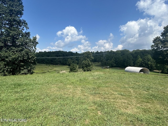 view of yard featuring a rural view and an outdoor structure