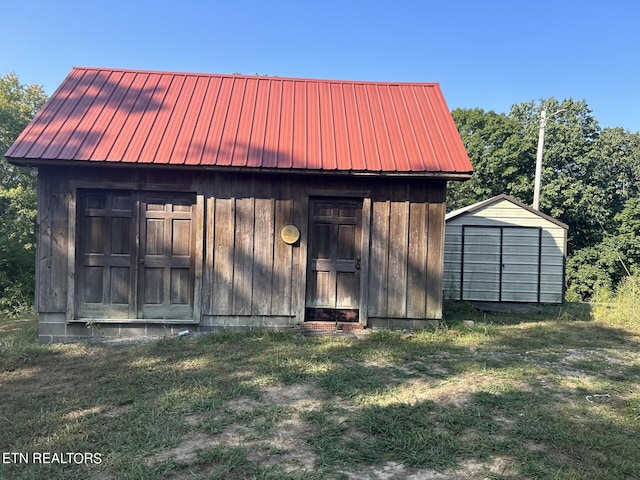 rear view of house with a shed and a yard