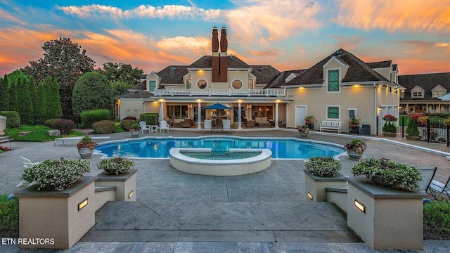 pool at dusk featuring a patio