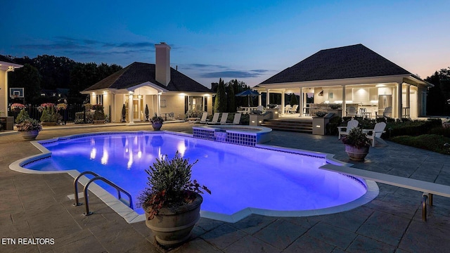 pool at dusk featuring a patio area