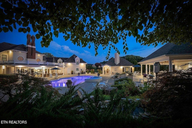 pool at dusk with a patio