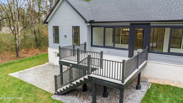 exterior space with a lawn, a shingled roof, and a patio