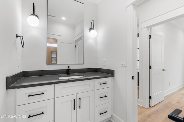 bathroom featuring baseboards, visible vents, vanity, recessed lighting, and wood finished floors