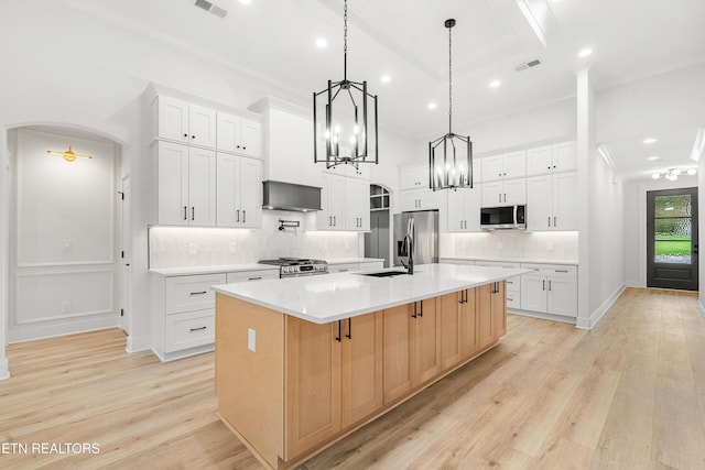 kitchen featuring stainless steel appliances, a large island with sink, light countertops, white cabinetry, and visible vents