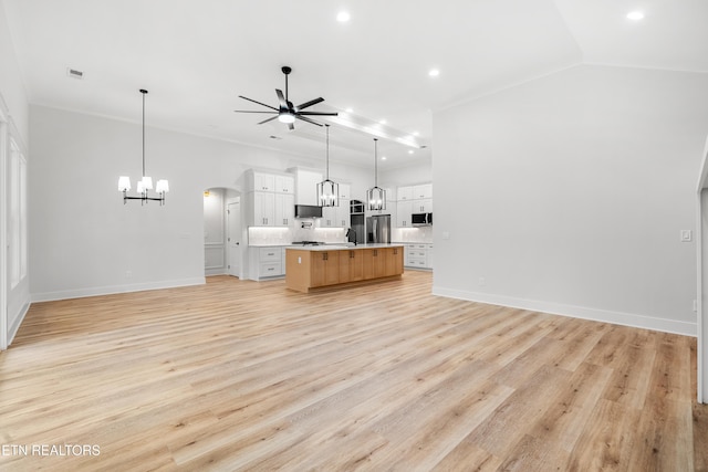 kitchen featuring pendant lighting, white cabinetry, light countertops, a large island with sink, and open floor plan