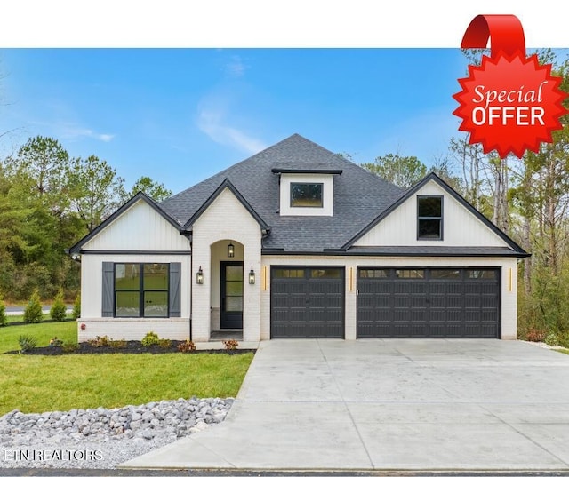 modern inspired farmhouse with a garage and a front lawn