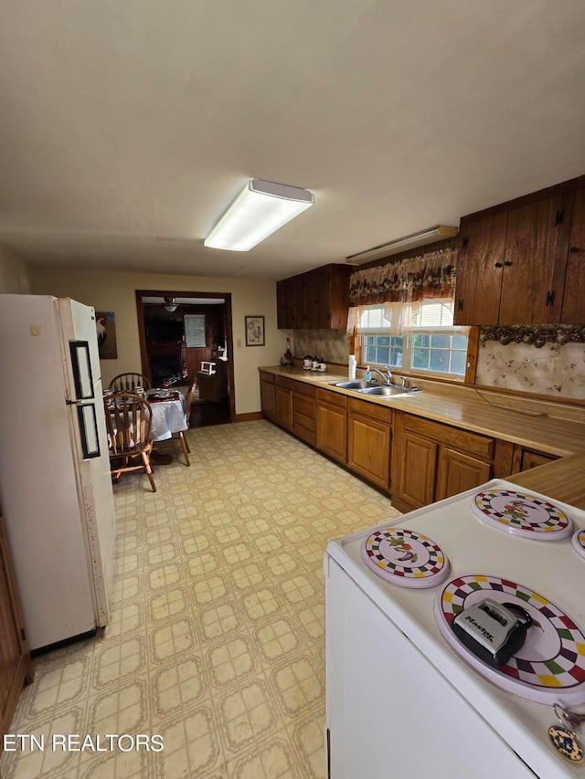 kitchen with decorative backsplash, light tile patterned floors, sink, and white fridge