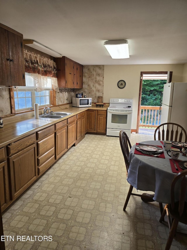 kitchen featuring sink, white appliances, and backsplash