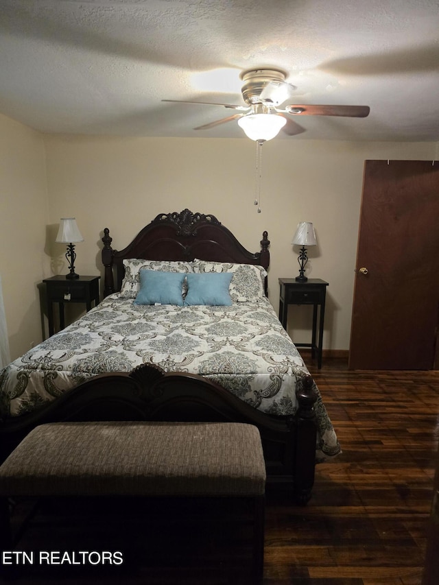 bedroom featuring dark wood-type flooring, ceiling fan, and a textured ceiling