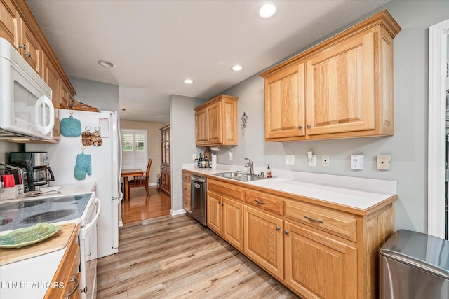 kitchen featuring recessed lighting, light countertops, light wood-style flooring, a sink, and white appliances