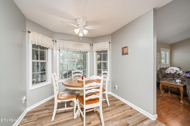 dining space featuring a ceiling fan, baseboards, and wood finished floors