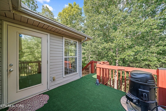 wooden terrace featuring a yard and area for grilling